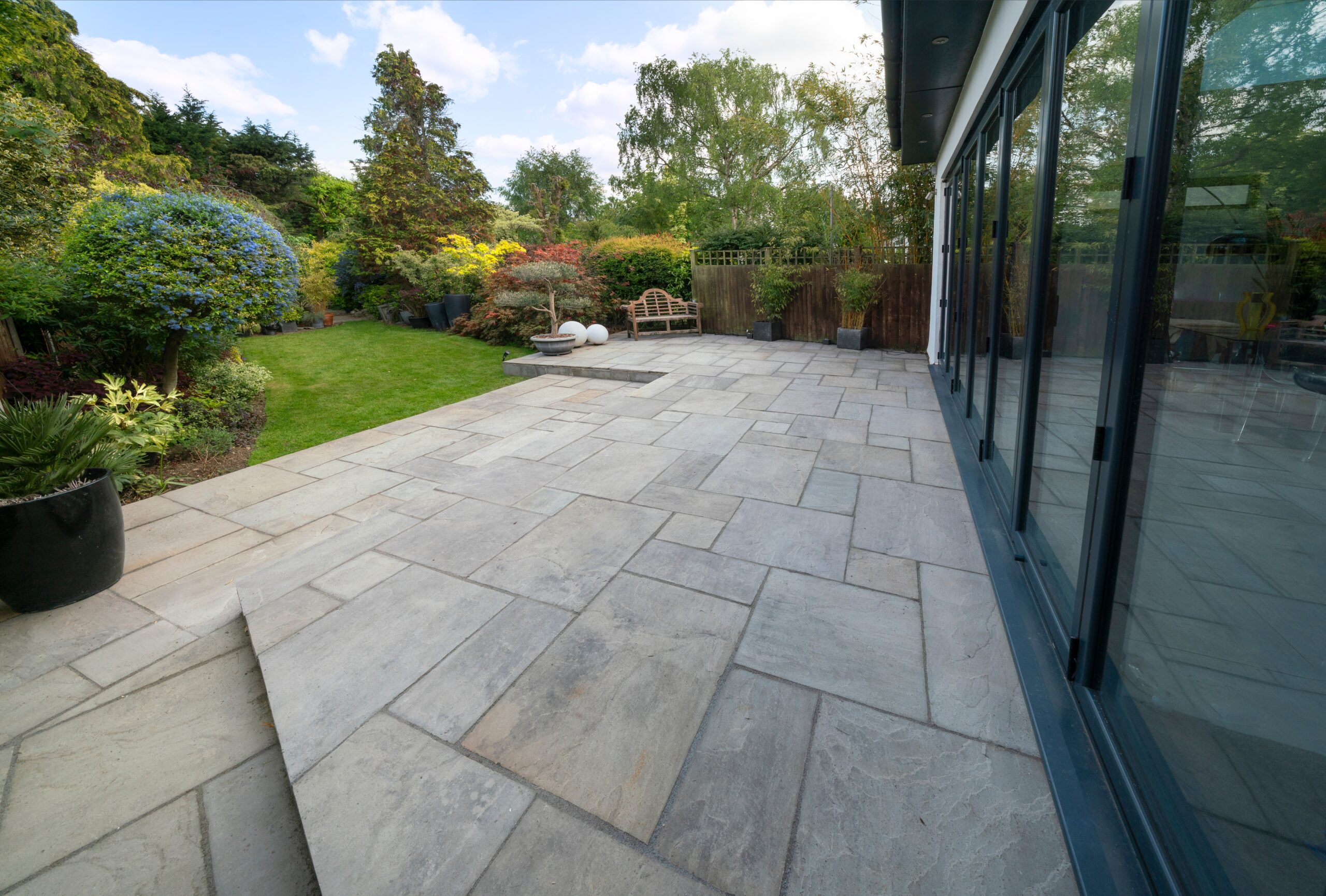 Beautiful,Indian,Sandstone,Patio,With,Attractive,Garden,And,Bifold,Doors.